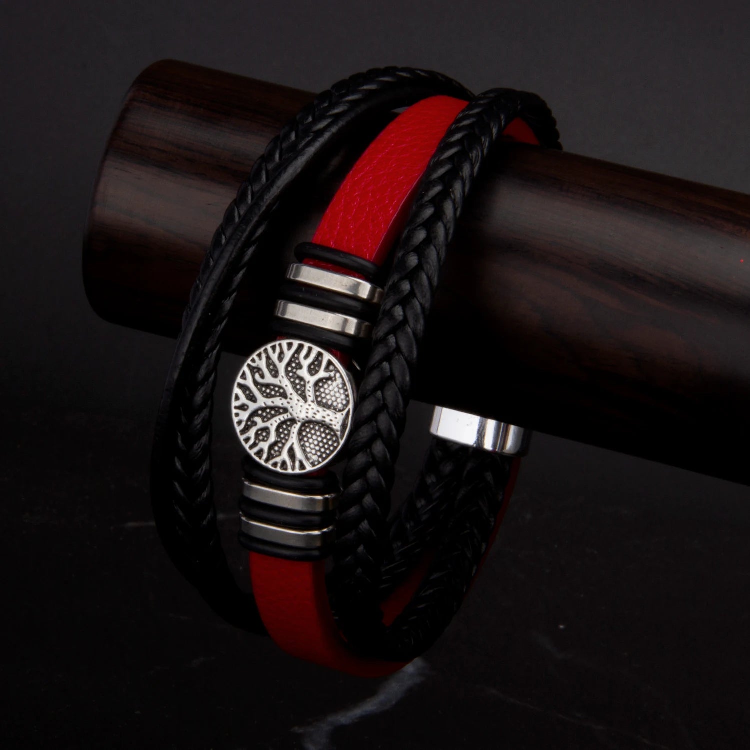 Black and red braided bracelet with a silver emblem on a dark background