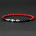 Red and black beaded bracelet with silver beads on a dark background